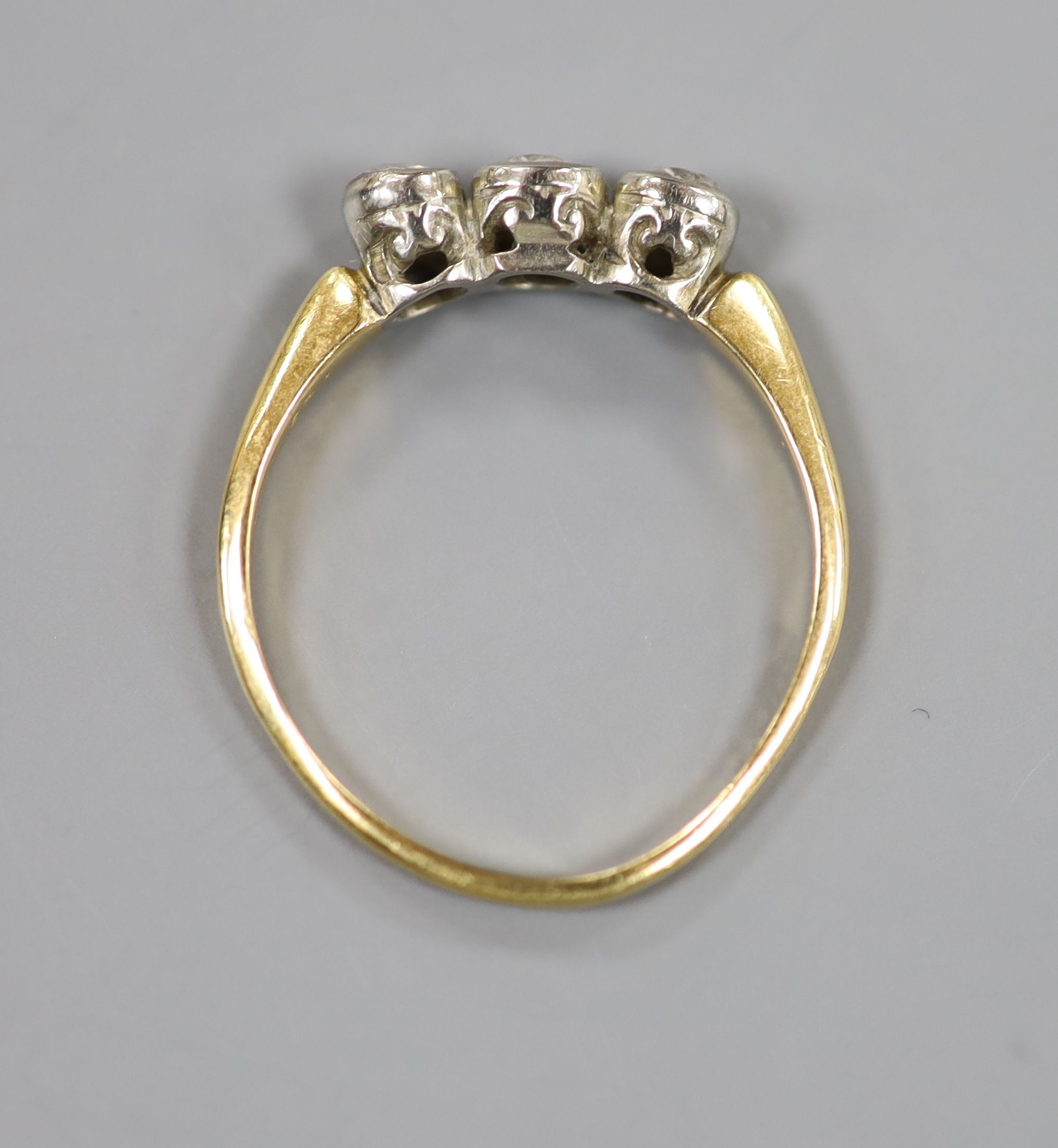 An 18ct and collet set three stone diamond ring, size R, gross weight 2.6 grams.